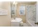 Bathroom featuring a white vanity, marble style shower and tub, and bright natural light at 205 Fox Hollow Dr, Clayton, NC 27527