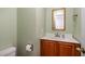 Cozy powder room with sage green walls, wood vanity, framed mirror and brushed nickel hardware at 205 Fox Hollow Dr, Clayton, NC 27527