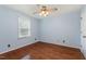 Bedroom with hardwood floors, ceiling fan, neutral paint, and large window providing natural light at 205 Fox Hollow Dr, Clayton, NC 27527
