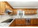 Well-lit kitchen featuring oak cabinets, stainless steel appliances, and granite countertops and light stone backsplash at 205 Fox Hollow Dr, Clayton, NC 27527