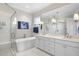 Bright bathroom with double vanity, soaking tub, and glass-enclosed shower at 2244 Plowridge Rd, Fuquay Varina, NC 27526