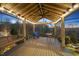 Relaxing outdoor deck showcases a swing bench and a dining area with wooded views at 2244 Plowridge Rd, Fuquay Varina, NC 27526