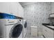 Functional laundry room with modern washer and dryer, cabinets and decorative wallpaper at 2244 Plowridge Rd, Fuquay Varina, NC 27526