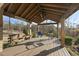 Covered patio with wooden swing and dining table under a ceiling fan, perfect for outdoor relaxation at 2244 Plowridge Rd, Fuquay Varina, NC 27526