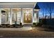 Inviting front porch featuring a wood ceiling, craftsman columns, rocking chairs, and a tastefully landscaped entrance at 2244 Plowridge Rd, Fuquay Varina, NC 27526