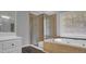 A bathroom featuring a glass enclosed shower, soaking tub, and neutral-toned tile at 229 Shillings Chase Dr, Cary, NC 27518