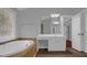 This bathroom features a tub, a vanity area with sink, and a door leading to another room at 229 Shillings Chase Dr, Cary, NC 27518