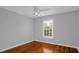 This bedroom features hardwood floors, ceiling fan, and natural light from the window at 229 Shillings Chase Dr, Cary, NC 27518
