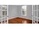 Inviting bedroom featuring hardwood floors, a window with natural light, and glass paneled french doors to another room at 229 Shillings Chase Dr, Cary, NC 27518