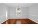 Classic dining room featuring hardwood floors, large windows, natural light, and a decorative chandelier at 229 Shillings Chase Dr, Cary, NC 27518