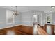 Open dining room with hardwood floors, large windows, natural light, crown molding, and an elegant chandelier at 229 Shillings Chase Dr, Cary, NC 27518