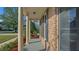 Charming front porch with brick columns, a red brick exterior and lush landscaping, offering a welcoming entrance at 229 Shillings Chase Dr, Cary, NC 27518