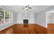 Cozy living room featuring hardwood floors, a fireplace, built-in shelving, and a large window at 229 Shillings Chase Dr, Cary, NC 27518