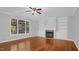 Warm living room with hardwood floors, a ceiling fan, fireplace, built-in shelving, and a large window for natural light at 229 Shillings Chase Dr, Cary, NC 27518