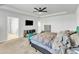 Bright primary bedroom featuring a trey ceiling, mounted TV and two upholstered chairs at 240 S Stonehaven Way, Clayton, NC 27527