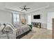 Bedroom featuring a trey ceiling, a mounted TV, dresser, and two upholstered chairs at 240 S Stonehaven Way, Clayton, NC 27527