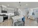 Bright, modern kitchen with stainless steel appliances, gray cabinets, and a large center island with seating at 240 S Stonehaven Way, Clayton, NC 27527