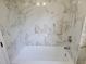Bright bathroom featuring a white tub with elegant marble-style tile surround at 3616 Open Sight Ct, Raleigh, NC 27616