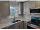 Kitchen featuring modern stainless steel appliances, gray cabinets, and marble-style countertops at 3616 Open Sight Ct, Raleigh, NC 27616