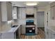 Updated kitchen featuring gray cabinets, stainless steel appliances, modern lighting, and granite countertops at 3616 Open Sight Ct, Raleigh, NC 27616