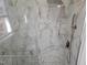 Bathroom shower featuring gorgeous marble tile, a hand-held sprayer and a shower bench at 3616 Open Sight Ct, Raleigh, NC 27616