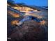 A backyard showing a stone path with landscaped lighting, leading to an outdoor entertainment area with a fire pit at 400 Access Dr, Youngsville, NC 27596