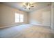 Bright bedroom features neutral carpet, a ceiling fan, and a large window at 400 S Eastwood Dr, Benson, NC 27504