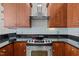 Elegant kitchen with dark countertops, stainless steel appliances, and wood cabinets at 400 W North St # 900, Raleigh, NC 27603