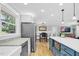 Open kitchen with white cabinets, granite countertops, stainless steel appliances, and kitchen island that flows into the breakfast nook at 409 Dartmouth Rd, Raleigh, NC 27609