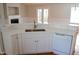 Modern kitchen featuring white countertops, stainless sink, dishwasher, and view to the backyard at 42 Galaxy Dr, Garner, NC 27529