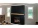Modern fireplace with a wooden mantel between two large windows at 503 Forest Rd, Oxford, NC 27565
