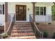 Inviting front porch with brick stairs, iron railings, and a stylish wood door, creating a warm and welcoming entrance at 503 Forest Rd, Oxford, NC 27565