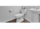 Simple, yet elegant half bathroom with a pedestal sink and wood-look flooring at 5813 Empathy Ln, Raleigh, NC 27616