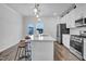 Bright kitchen with stainless appliances, island with chairs and bar pendant lighting at 5813 Empathy Ln, Raleigh, NC 27616