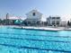A community pool in a rural location with an elegant clubhouse and lounge chairs at 5813 Empathy Ln, Raleigh, NC 27616