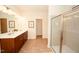 Spacious bathroom featuring double sinks, a wooden vanity, and a glass-enclosed shower at 612 Marian Way, Sanford, NC 27330