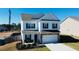 Charming two-story home featuring white siding, dark shutters, and a stone-accented garage at 612 Marian Way, Sanford, NC 27330