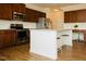 Well-lit kitchen features stainless appliances, wood cabinets and a center island with seating at 612 Marian Way, Sanford, NC 27330