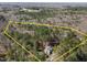 Expansive aerial view of a wooded lot with mature trees and a beautiful home nestled within the property lines at 6610 Maynard Farm Rd, Chapel Hill, NC 27516