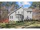 Rear view of home featuring well-kept lawn, wooden deck and fence surrounded by mature trees at 6610 Maynard Farm Rd, Chapel Hill, NC 27516