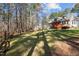 Expansive backyard with lush grass, mature trees and a wooden deck great for outdoor enjoyment at 6610 Maynard Farm Rd, Chapel Hill, NC 27516