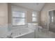 Bright bathroom with a soaking tub, tiled floor, and a toilet with windows in close proximity at 6610 Maynard Farm Rd, Chapel Hill, NC 27516