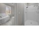 White tiled bathroom featuring a tub and shower at 6610 Maynard Farm Rd, Chapel Hill, NC 27516