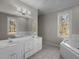 Bathroom features double sinks, ample lighting, and a separate tub in a bright space at 6610 Maynard Farm Rd, Chapel Hill, NC 27516