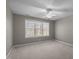 Comfortable bedroom featuring plush carpet, a ceiling fan, and a window with scenic outdoor views at 6610 Maynard Farm Rd, Chapel Hill, NC 27516