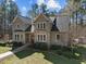 Impressive home featuring a stone facade, walkway, complemented by lush landscaping and mature trees at 6610 Maynard Farm Rd, Chapel Hill, NC 27516