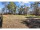 Beautiful wooded land features a spacious, grassy area surrounded by mature trees and a charming fence line at 6610 Maynard Farm Rd, Chapel Hill, NC 27516