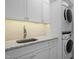 Laundry room with granite countertops, stainless steel sink, and stacked washer/dryer at 6610 Maynard Farm Rd, Chapel Hill, NC 27516
