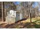 Outdoor storage and greenhouse provides solutions for storage and gardening with adjacent wooden fence and trees at 6610 Maynard Farm Rd, Chapel Hill, NC 27516