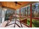 Covered porch with a wood ceiling fan offering picturesque views of the surrounding wooded property at 6610 Maynard Farm Rd, Chapel Hill, NC 27516